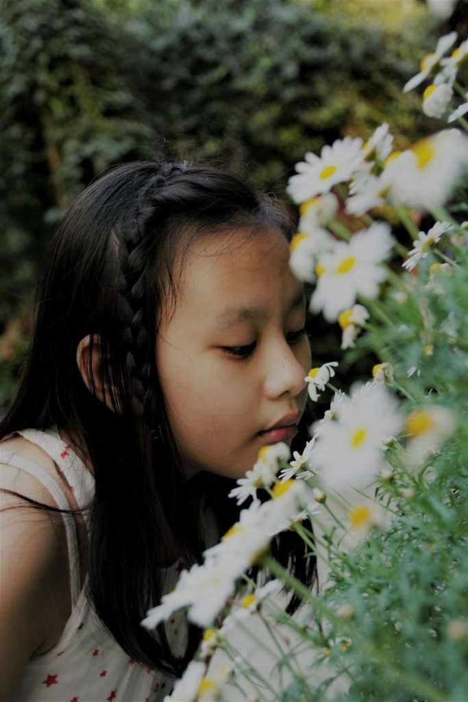 Young girl smelling flowers for nervous system regulation